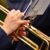 Close-up of hands with red nails playing a golden trumpet, sheet music visible above.